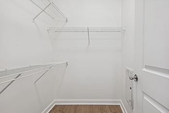 an empty closet with white walls and a white door
